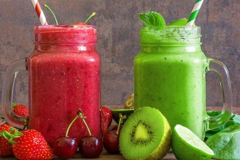 Freshly blended fruit and vegetable smoothies in glass jars on rustic woode.. Stock Photos