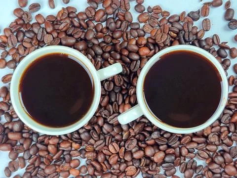 Freshly Brewed Coffee in Cups Surrounded by Aromatic Coffee Beans and Rich .. Stock Photos