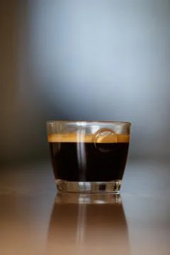 Freshly brewed espresso from ground beans in a transparent glass, with aromatic Foto stock