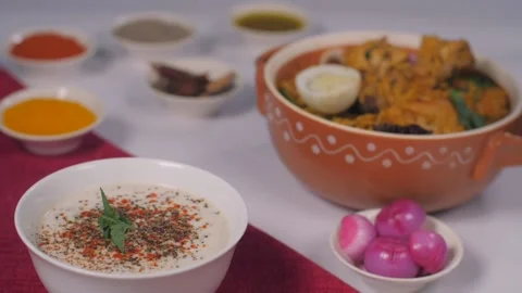 Freshly chopped mint leaves falling / dropping in a bowl of Raita for garnishing Stock Footage 153392331