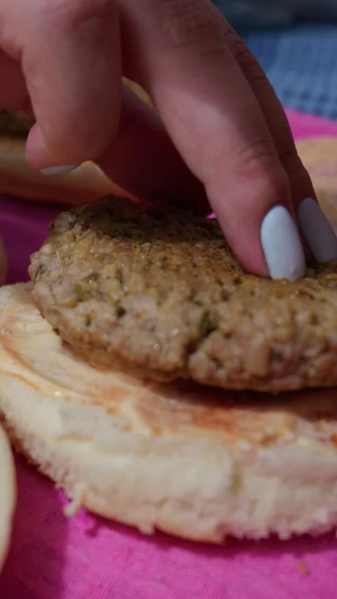 Freshly Cooked Beef Burger Patties Placed on Sauce Covered Hamburger Buns Stock Footage 342000960