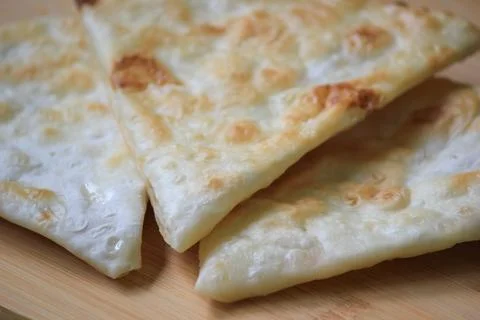 Freshly cooked crispy triangle shaped flatbread pieces served on a wooden b.. Fotos Stock