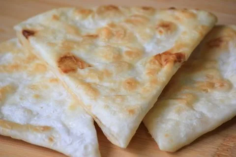 Freshly cooked crispy triangle shaped flatbread pieces served on a wooden b.. 스톡 사진