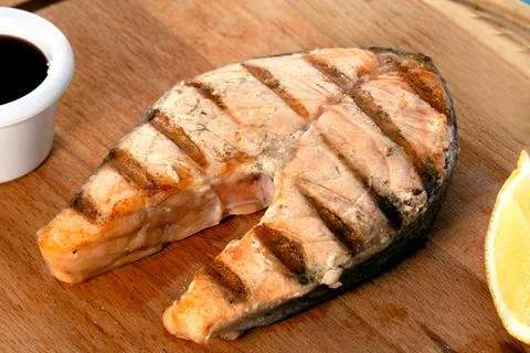 Freshly cooked delicious salmon steak with spices and herbs, grilled. Healthy Stock Photos