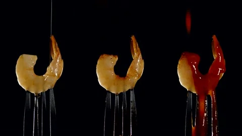 Freshly cooked juicy shrimp on a fork is on a black background. Stock Footage 190610909