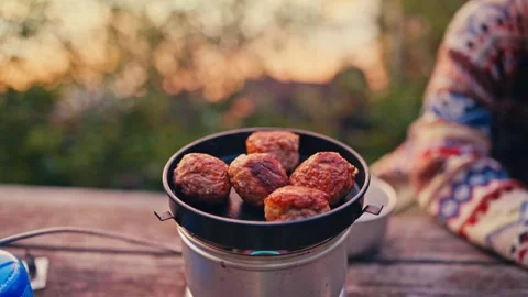 Freshly Cooked Meatballs Sizzle Over a Small Outdoor Stove as the Evening Light Stockbeeldmateriaal 335351982
