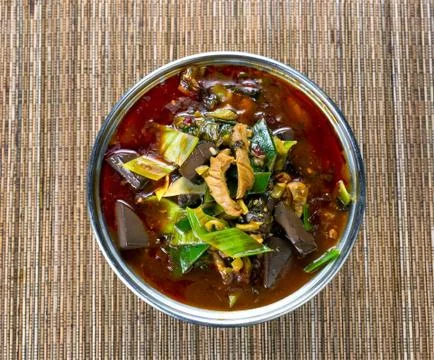 Freshly cooked spicy vegetable soup in pot on bamboo mat background Stock Photos