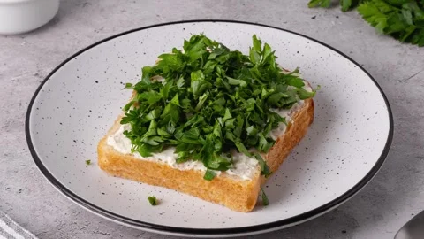 Freshly cut herbs on a slice of bread with cream cheese Stock Footage 335243784