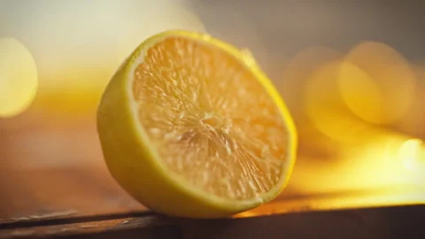 A freshly cut lemon half lies on a cutting board the pulp and zest slowly dr Stock Footage 331312858