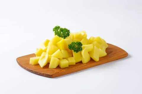 Freshly cut pineapple chunks on wooden board Stock Photos