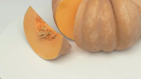 A Freshly Cut Pumpkin Featuring a Beautiful Slice Artistically Placed on a Plate Stockbeeldmateriaal 285511042