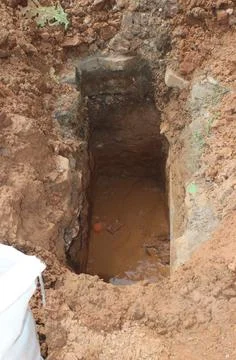 Freshly dug grave pit on the side of the road inside the residence for inst.. Stock Photos
