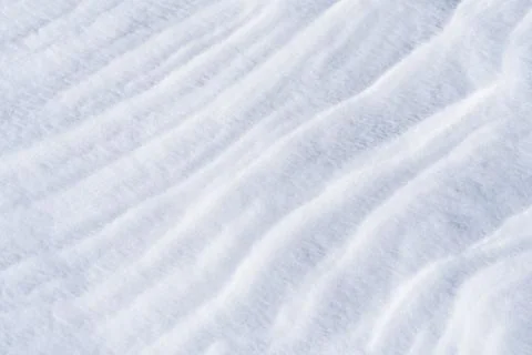 Freshly fallen snow surface looking like dunes shaped by wind. Stock Photos