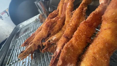 Freshly fried crispy breaded ebi fry shrimp on a rack, close up, izakaya, Japan Stock Footage 343376276