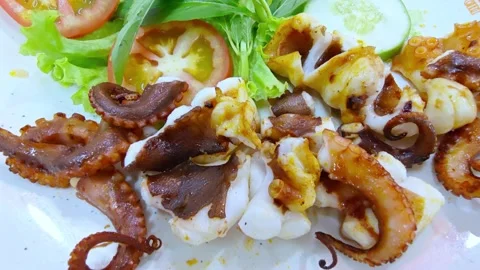 Freshly grilled octopus served on a white plate at a seaside restaurant. Seafood Видео 336993135