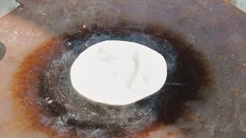 A freshly made flatbread cooking Stock Footage 324607167