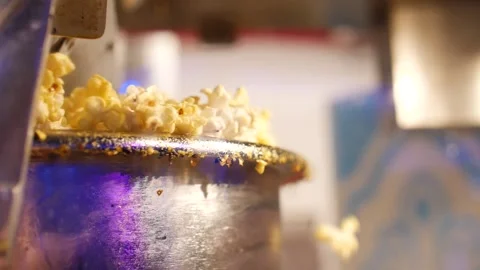 Freshly made popcorn spilling over the edge of a pot or machine Stock Footage 166663992