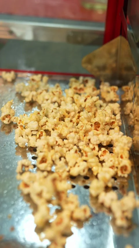 Freshly made sweet popcorn inside a red commercial popcorn maker machine Stock Footage 340513700