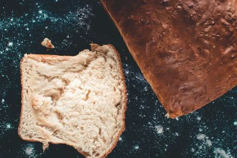 Freshly made white bread on a black wooden background. Stock Photos