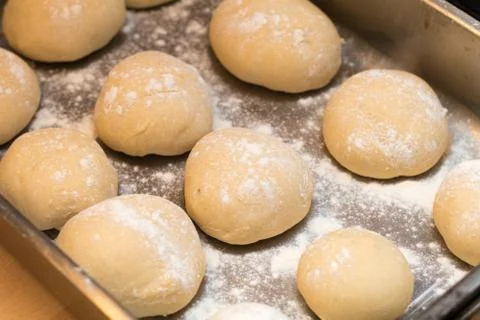 Freshly made white bread rolls proving Stock Photos