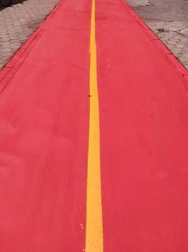 Freshly painted and empty red bike path. Stock Photos