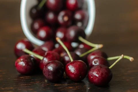 Freshly picked cherries in a ceramic mug on a wooden table 写真素材