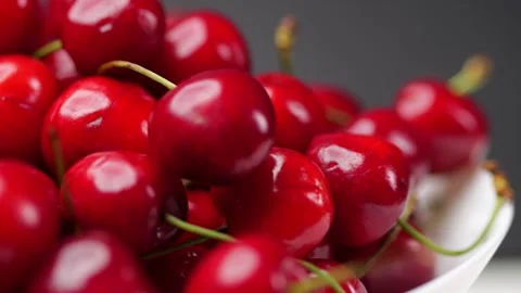 Freshly picked cherries spin on a white plate. Tasty fruits on a dark backg.. Stock Footage 277823725