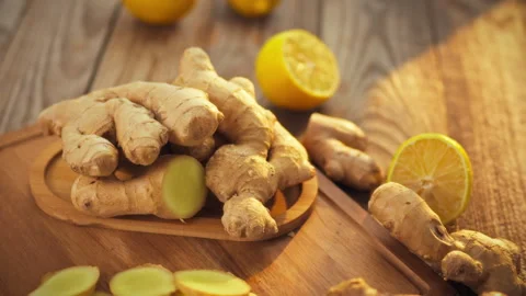 Freshly picked ginger root is arranged on a wooden plate set against a simpl Stock Footage 331353724