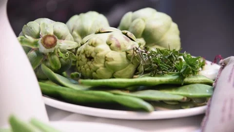 Freshly picked green artichokes. A plate of artichokes and green beans Stock Footage 153273953