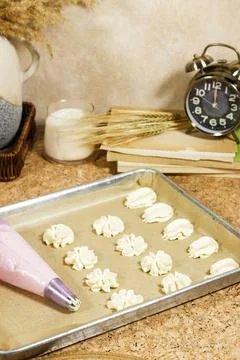 Freshly Piped Cookie Dough on Baking Tray With Piping Bag in Cozy Kitchen and Vi Stock Photos