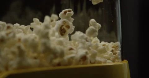 Freshly popped kernels bounce inside a glass container. Isolated. Stock Footage 64295475