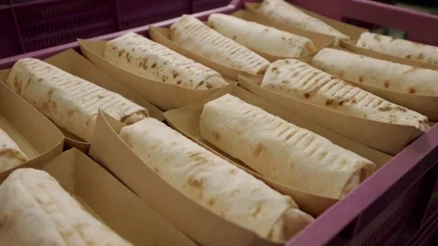 Freshly prepared flatbreads arranged in a purple tray with parchment paper Stock Footage 340172443