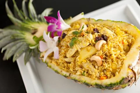 Freshly prepared pineapple fried rice served inside of a pineapple carved lik Stock Photos