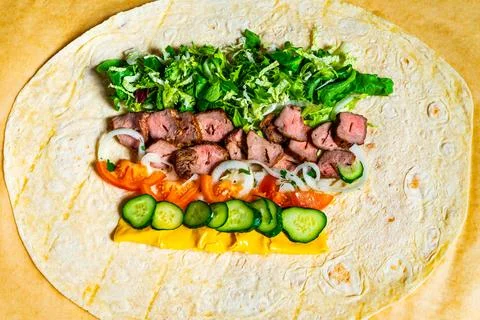 Freshly prepared wrap with assorted vegetables and meat filling Stock Photos