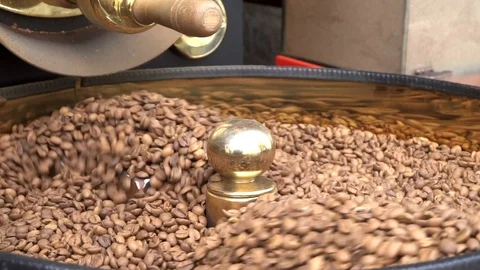 Freshly roasted aromatic coffee beans rotating slow motion in roasting machine Video stock 92937813