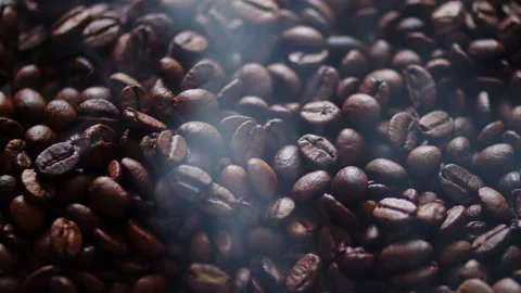 Freshly roasted brown coffee beans with hot smoke rising from them. Stock Footage 336182440