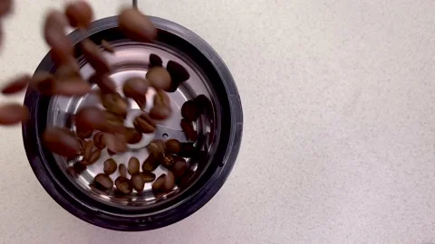 Freshly roasted coffee beans are poured into a coffee grinder.  Stock Footage 155617892