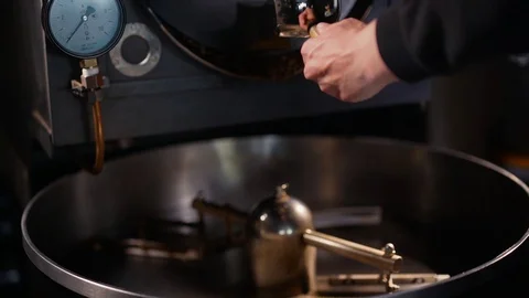Freshly roasted coffee beans on a cooling tray, being mixed by a rotating Video stock 129309807