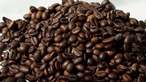 Freshly roasted coffee beans falling from pack,woman hands, on table 库存影片 201524000