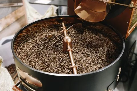 The freshly roasted coffee beans from a large old coffee roaster being stirre 写真素材