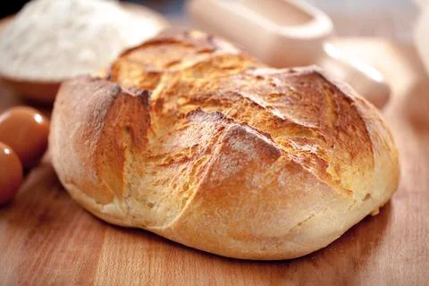 Freshly rustic loaf of bread isolated on wooden table background Stock Photos