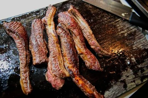 Freshly Seared Beef Short Ribs on a Dark Wooden Cutting Board Stock Photos