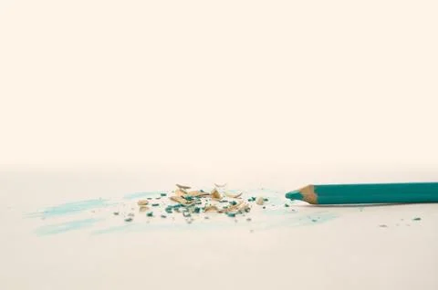 Freshly sharpened green colored pencil next to the wood shavings. 写真素材