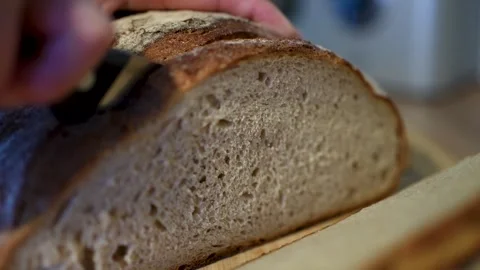 Freshly sliced, artisan bread on a rustic wooden cutting board Stock Footage 283486429