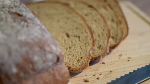 Freshly sliced, artisan bread on a rustic wooden cutting board Stock Footage 283486463