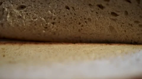 Freshly sliced, artisan bread on a rustic wooden cutting board Stock Footage 283486513