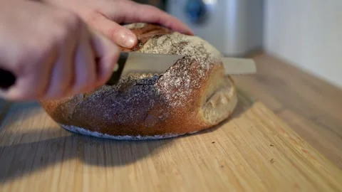 Freshly sliced, artisan bread on a rustic wooden cutting board Stock Footage 283486665