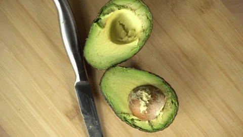 Freshly sliced Avocado on a cutting board rotating Stock Footage 227014341