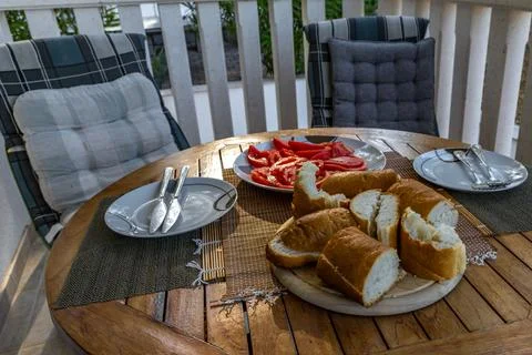 Freshly sliced bread, red tomatoes, Mediterranean breakfast on the terrace .. Stock Photos