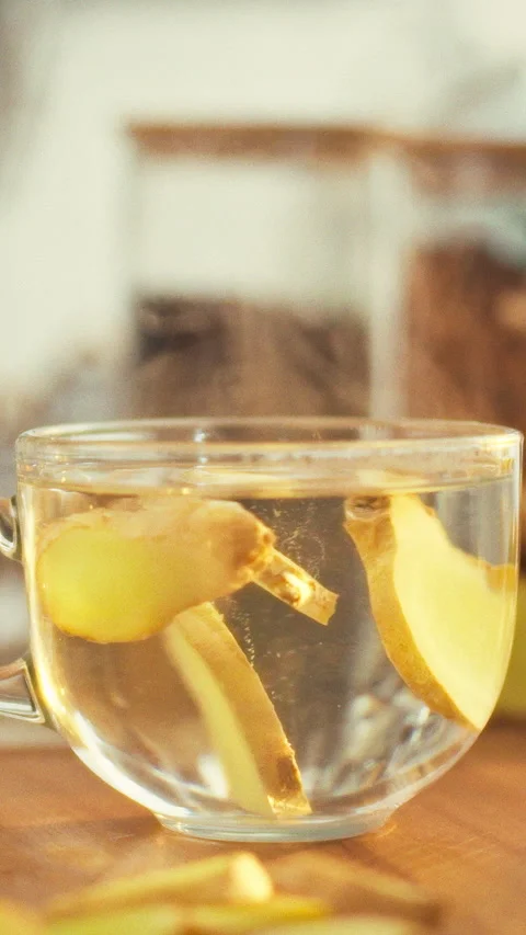 Freshly sliced ginger root spirals in clear cup rhizome releasing minerals a Stock Footage 341284024